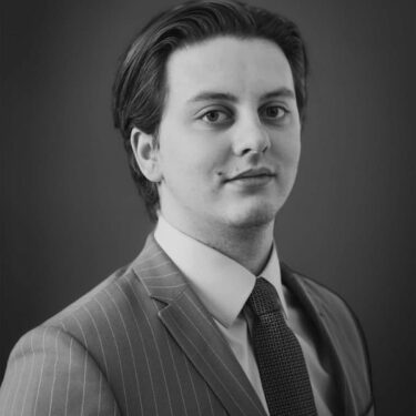 Portrait en noir et blanc d’Édouard Lecerf, chargé d’affaires chez Haussmann Fusac, portant un costume, une cravate et une chemise blanche.